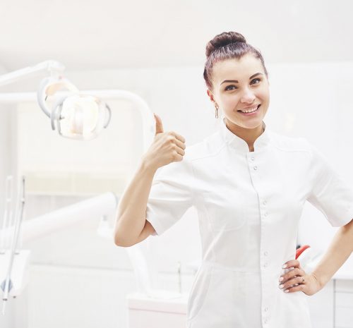 happy-young-female-dentist-with-tools-over-medical-Z3WGLGH-1.jpg