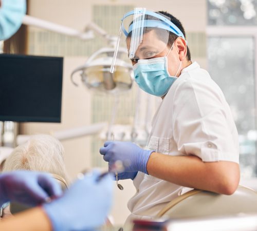 Man in protective uniform sitting on the dentist chair